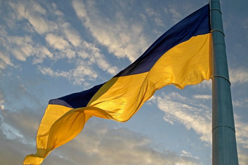 Український прапор як символ незалежності держави Державний прапор України майорить на флагштоку на фоні неба